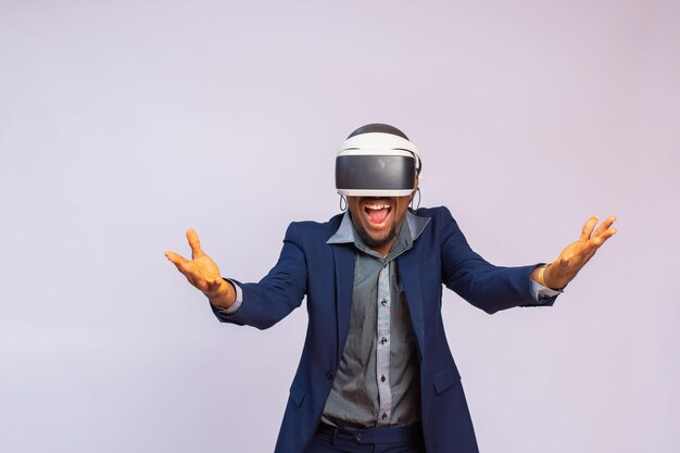 Zdumiony młody mężczyzna grający w gry wideo w goglach VR lub okularach 3D, noszący na głowie gogle wirtualnej rzeczywistości