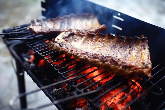 żeberka wieprzowe na grillu węgle do gotowania / świeże mięso wieprzowina gotowana na węglu, letni domowy posiłek, żeberka grillowane
