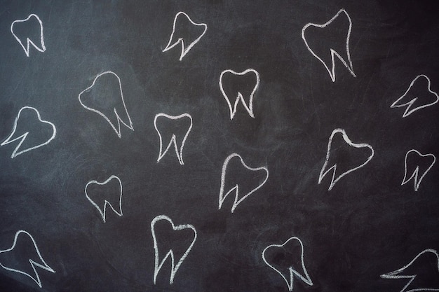 Zdjęcie zęby narysowane kredą na czarnej tablicy dentystyka koncepcja