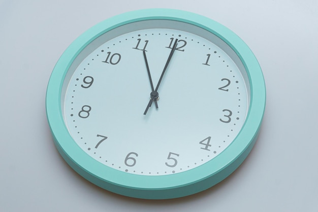 Zegar ścienny pokazujący różne godziny na białym tle