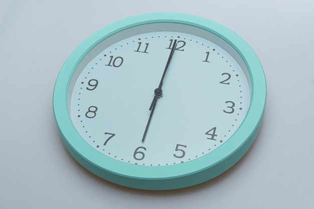 Zegar ścienny pokazujący różne godziny na białym tle