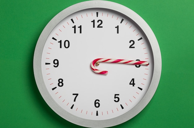 Zegar świąteczny ze wskazówkami z trzciny cukrowej pokazuje godzinę trzecią