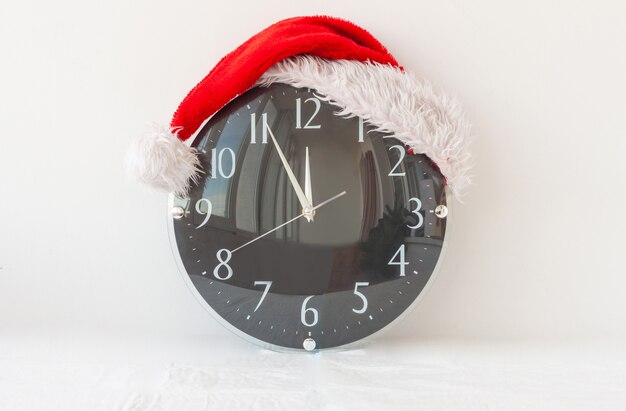 Zegar W Czapce świętego Mikołaja Na Białym Tle Wskazuje Pięć Minut Do Dwunastej