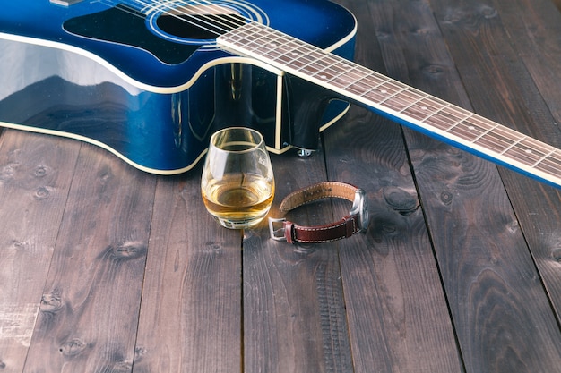 Zegarek i gitara na starym drewnianym stole