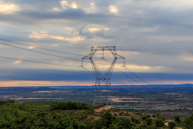 Żelazna wieża energii elektrycznej na górze o wschodzie słońca