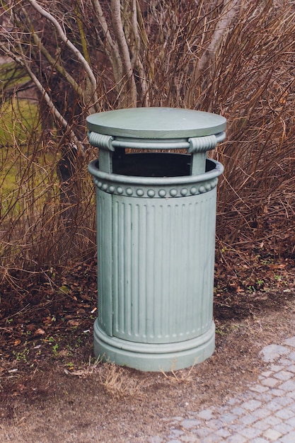 Żeliwna szara urna stoi w jesiennym parku.