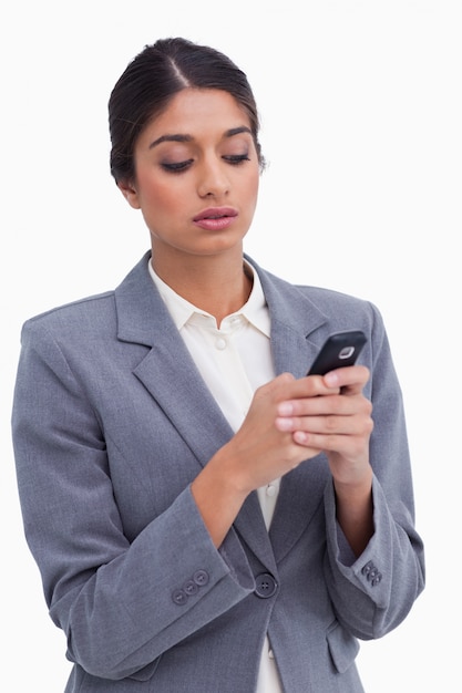 Żeńska przedsiębiorcy writing wiadomość tekstowa na jej telefonie komórkowym
