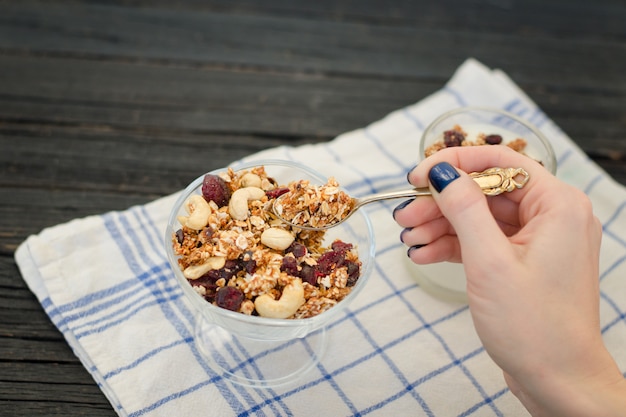 Żeńska ręka nalewa w jogurtowej muesli.