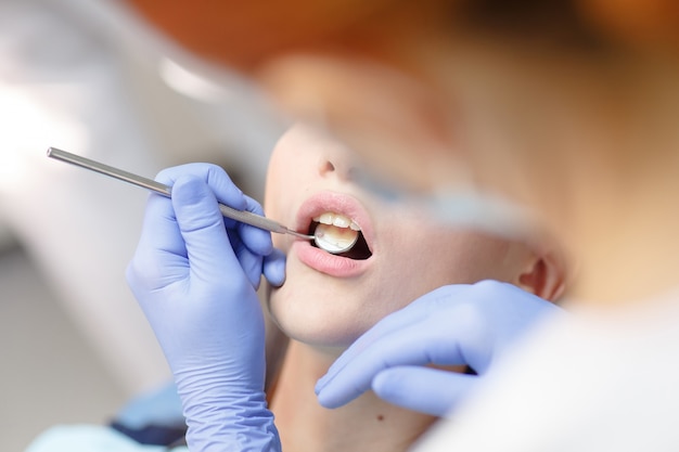 Żeński dentysta sprawdza cierpliwych dziewczyna zęby