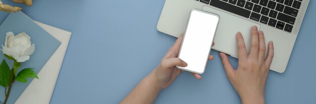Żeński freelancer używa smartphone na błękitnym biurku