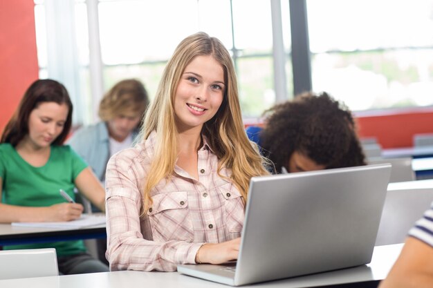 Żeński uczeń używa laptop w sala lekcyjnej