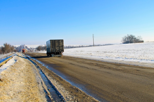 Zepsuta popękana asfaltowa droga zimą