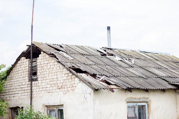 Zepsuty dach po huraganie, dom we wsi, zniszczony dach domu mieszkalnego