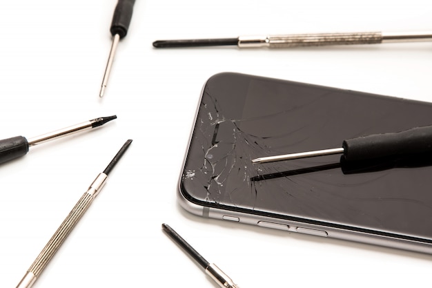 Zepsuty smartfon i małe śrubokręty do naprawy
