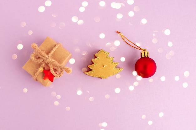 Zdjęcie zero waste christmas flatlay na fioletowym tle pudełka na prezenty świeca i czerwona zabawka nowy rok