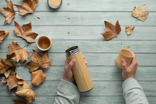 Zero Waste Kawa W Bambusowych Kubkach Z Ekologicznego Izolowanego Metalowego Termosu Jesienią. Ręce Trzymające Kolbę I Kubek.