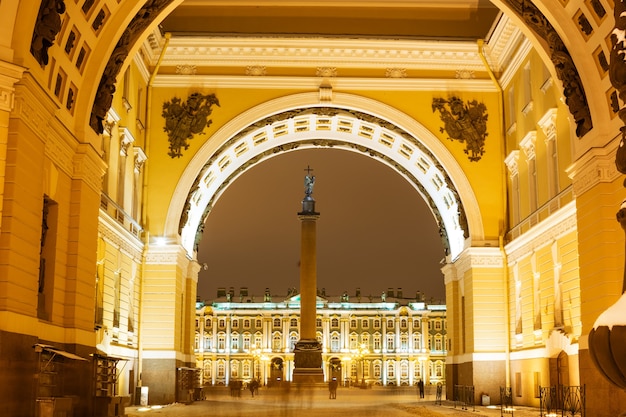 Zespół architektoniczny z widokiem na kolumnę aleksandrową przez łukowy plac pałacowy w nocy arty...