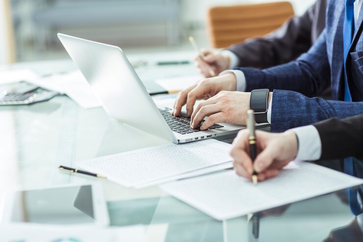 Zespół biznesowy przeprowadzający analizę raportów marketingowych na stanowisku pracy w biurze