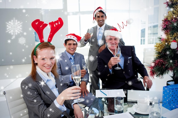 Zdjęcie zespół biznesowy wznosi toast z szampanem na przyjęciu bożonarodzeniowym przed opadami śniegu