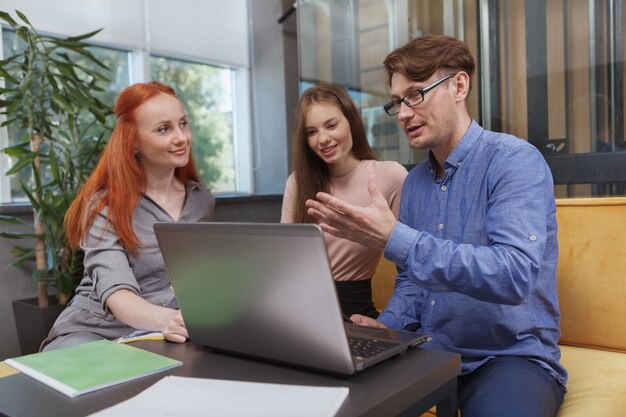 Zespół biznesowy za pomocą laptopa podczas spotkania w nowoczesnym miejscu pracy