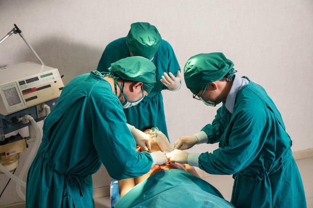 Zespół chirurgów w fartuchu chirurgicznym wykonujący operację ciężko rannego pacjenta na sali operacyjnej w szpitalu