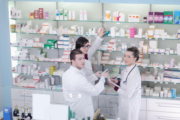 Zespół farmaceutów, chemików, kobiet i mężczyzn stojących w aptece