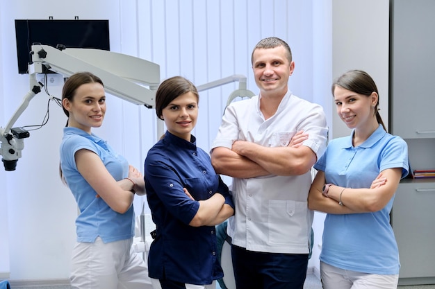 Zespół kolegów dentystów, portret lekarzy patrząc w kamerę w gabinecie stomatologicznym. Personel, medycyna, stomatologia i opieka zdrowotna