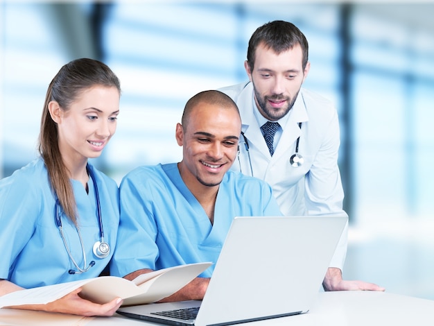 Zespół lekarzy rozmawiający o ekspertyzie w szpitalu przez laptop