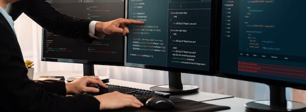 Zespół programistów współpracujący w biurze, wyświetlający skrypt kodowania na monitorze komputera Programista i inżynier oprogramowania pracujący w firmie zajmującej się tworzeniem technologii Trailblazing