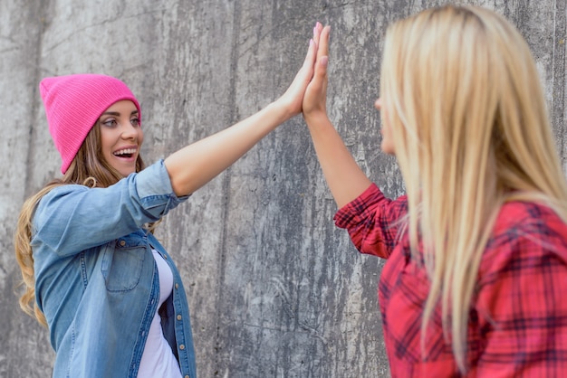 Zdjęcie zespół świętuje pracę dzieci dać klapsa, klejenie koncepcji brunetki blond fryzurę. portret śliczny funky zabawny słodki piękny piękny całkiem zadowolony miły z uśmiechniętym uśmiechem pani na białym tle szarym