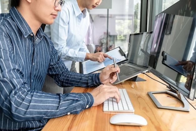 Zespół Traderów Biznesowych Sprawdzający Giełdę Online, Analizujący Dane Z Wykresów Na Ekranie Laptopa Do Burzy Mózgów Na Temat Handlu Online Podczas Wspólnej Pracy W Biurze