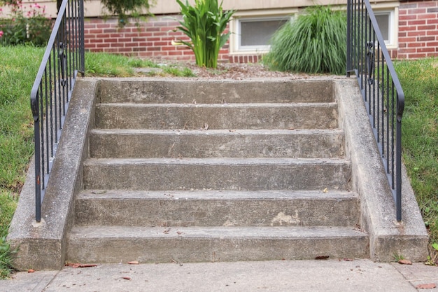 Zestaw betonowych stopni z czarną balustradą z napisem „krok”.