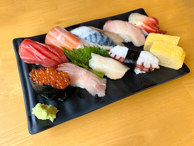 Zestaw japońskiego sushi premium na czarnym talerzu z wasabi
