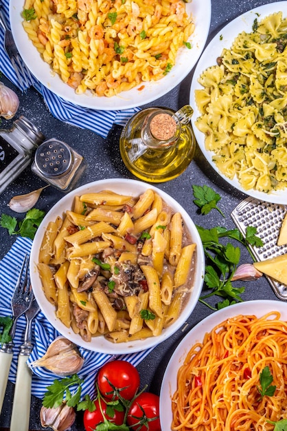 Zestaw makaronów z różnymi sosami na białym tle kafelkowym Spaghetti farfalle penne fusilli makaron z owocami morza szpinak sos pomidorowy carbonara Włoska kolacja Koncepcja kuchni śródziemnomorskiej