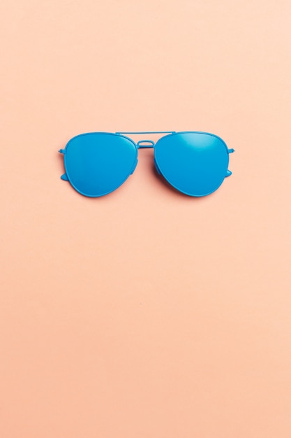 Zestaw modnych kosmetyków: okulary przeciwsłoneczne na pastelach.