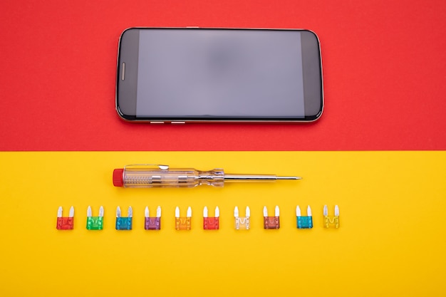 Zestaw narzędzi elektrycznych z czarnym smartfonem na kolorowe