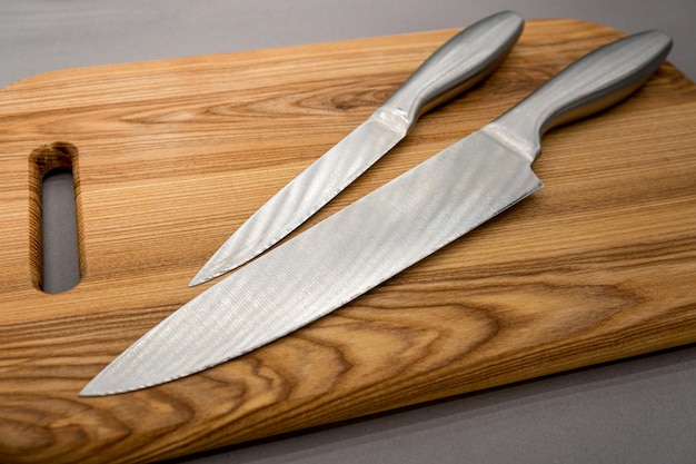 Zestaw noży kuchennych deska do krojenia na białym tle na szarym tle