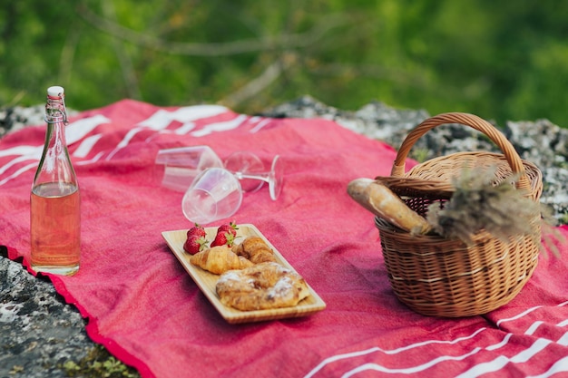 Zestaw piknikowy z truskawkami croissanty bagietka wino wiklinowy kosz na piknik