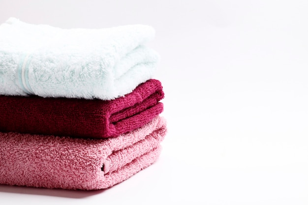 Zestaw ręczników w różnych kolorach na białym tle. Miejsce na tekst
