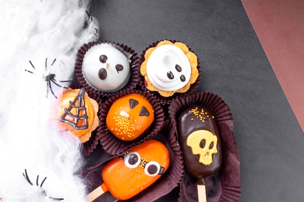 Zdjęcie zestaw słodyczy halloween na czarnym i brązowym tle