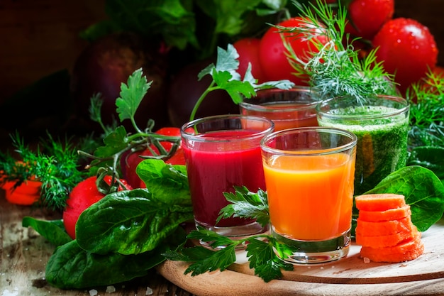 Zestaw soku warzywnego w okularach burak pomidorowy szpinak marchewki zioła i świeże warzywa na tle drewniane selektywne focus