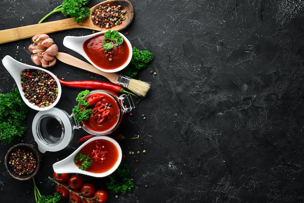 Zestaw sosów pomidorowych na czarnym tle kamienia Ketchup sos barbecue Sos pomidorowy Widok z góry Wolne miejsce na tekst