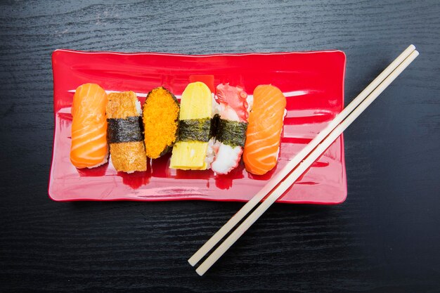 Zestaw sushi sashimi podawany na czerwonym talerzu