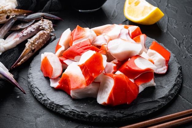 Zestaw świeżego mięsa kraba surimi, na kamiennej desce, na czarnym stole