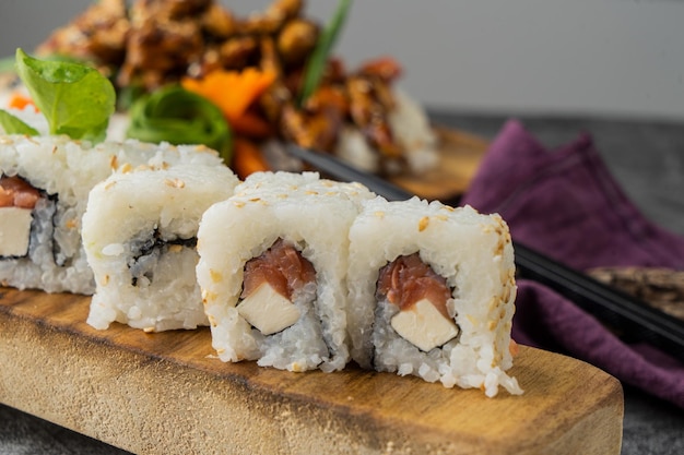 Zestaw świeżych rolek sushi z łososiem, awokado i czarnym sezamem z bliska. Kalifornijska rolka