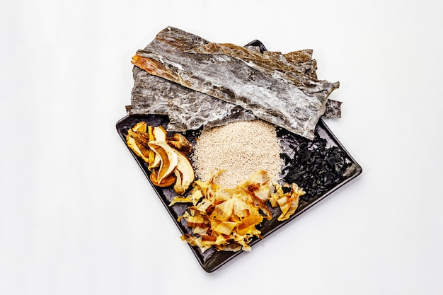 Zestaw tradycyjnego japońskiego składnika do gotowania podstawowego bulionu dashi. Algi kombu i wakame, katsuobushi i suche grzyby. Odosobniony