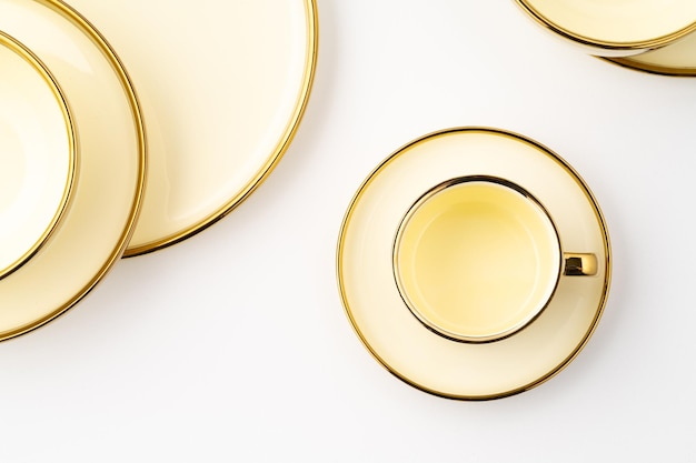 Zdjęcie zestaw złotych luksusowych ceramicznych przyborów kuchennych na białym tle