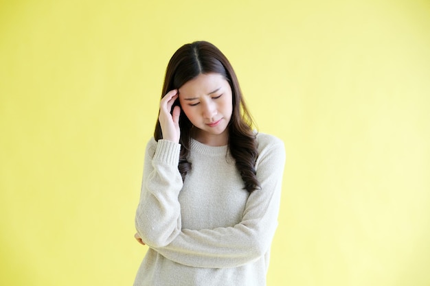 Zestresowana Młoda Azjatycka Kobieta Stojąca Nad Odosobnionym żółtym Tłem