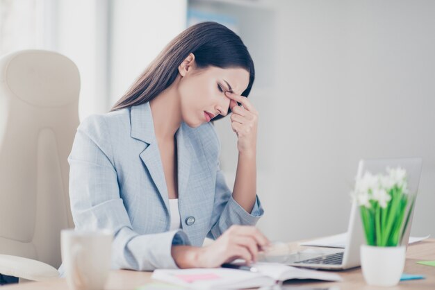 Zestresowany bizneswoman pracuje przy biurku