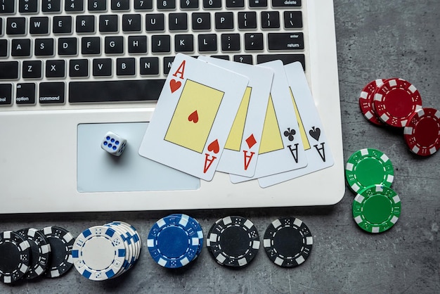 Żetony kasynowe i karty do gry na laptopie koncepcja gry w pokera online
